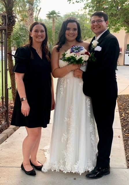 bride and groom smiling with wedding officiant